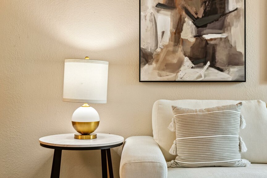 Cozy living room corner with sofa, striped throw pillow and table lamp