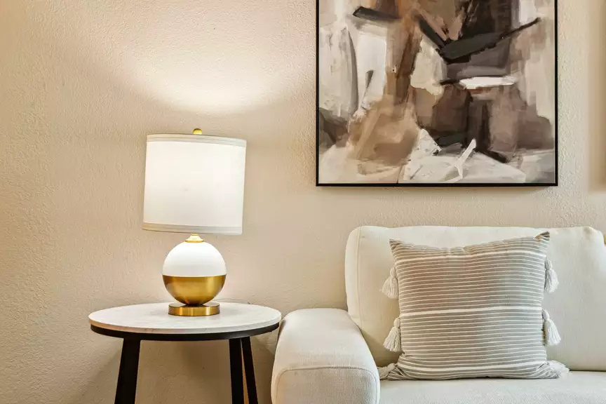 Cozy living room corner with sofa, striped throw pillow and table lamp