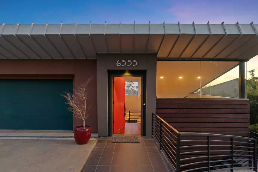 Modern front entrance with open red door and garage