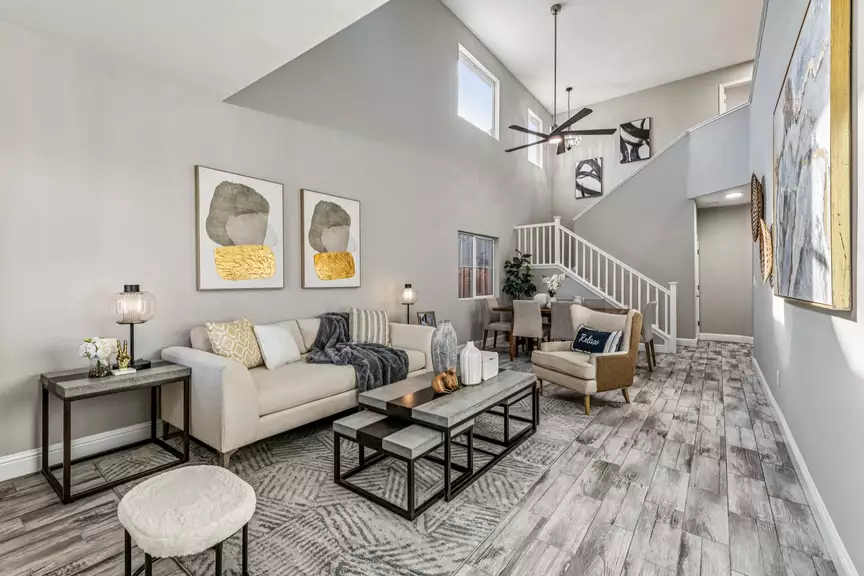 Bright two-story living room with sofa, coffee table and staircase