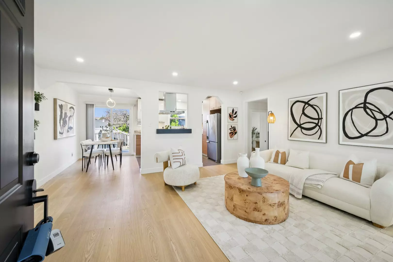 Bright open living room with modern sofa, coffee table, and dining area beyond