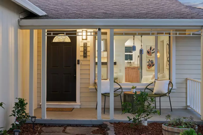 Covered front porch with seating and a black front door