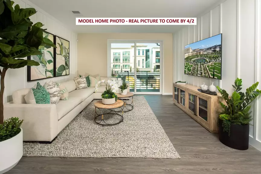 Bright modern living room with sofa, coffee tables and wall-mounted TV